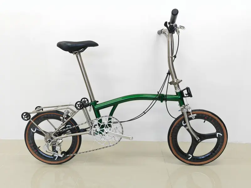 Emerald green and raw titanium 16-inch trifold with black tri-spoke carbon wheels