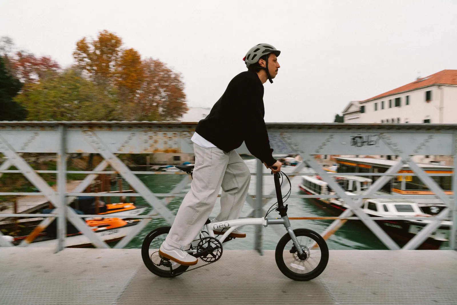 A rider on a white Java Neo 3 crossing a canal footbridge in Venice