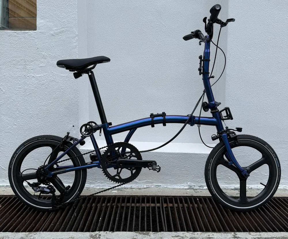 A chameleon-blue Leggero 16-inch trifold with black tri-spoke wheels