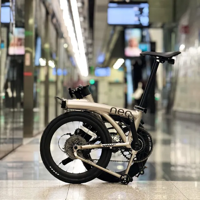 A champagne Java Neo 3 half-folded on the floor of an MRT station