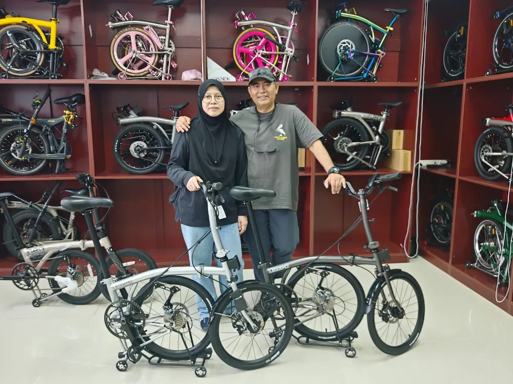A couple with their two new folding bikes in the Jackbikesg showroom