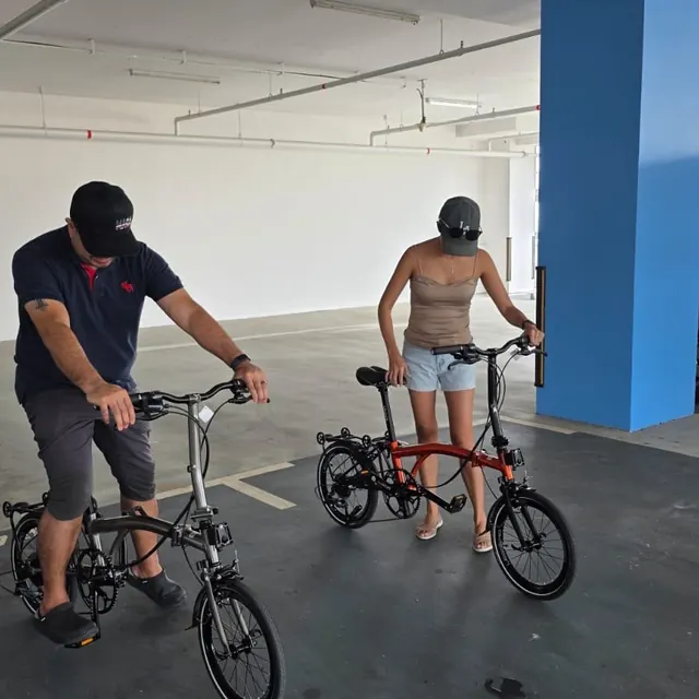 A couple test-riding a grey and a red Leggero A9 in a car park