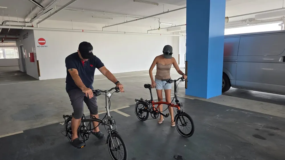 A couple test-riding a grey and a red Leggero A9 in a car park