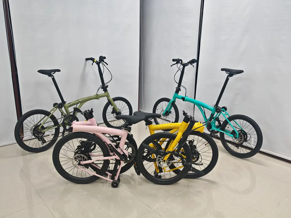 Four Java Neo 3 ECO bikes in the showroom, two unfolded and two folded, in moss green, sea salt green, pink and yellow